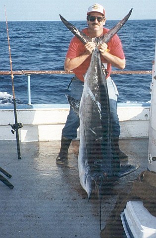 Peter lifting a marlins tail